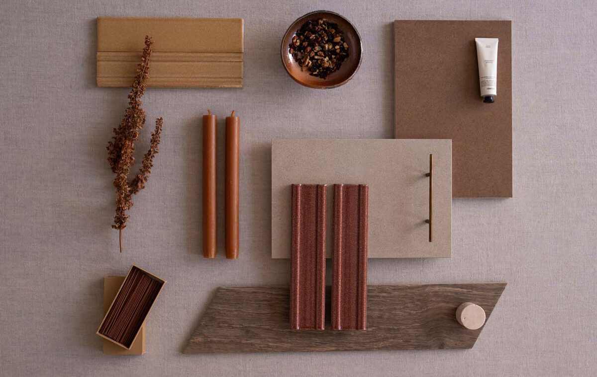 Surface in warm tones with terracotta-hued tiles and decorative elements such as candles and dry twigs.