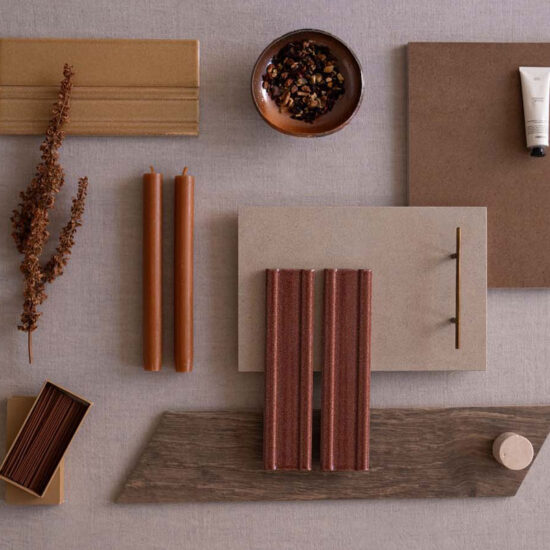 Surface in warm tones with terracotta-hued tiles and decorative elements such as candles and dry twigs.