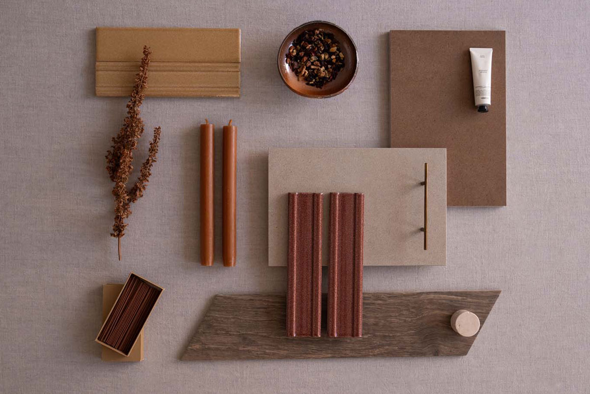 Surface in warm tones with terracotta-hued tiles and decorative elements such as candles and dry twigs.