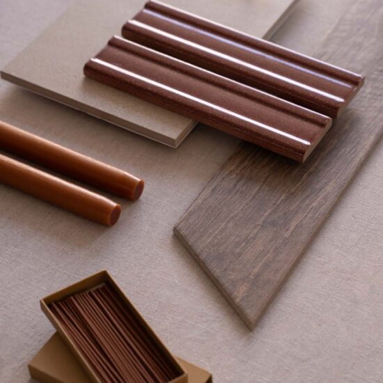 Warm tones of ceramic samples and materials, with wood effects and glossy finish on a neutral background.