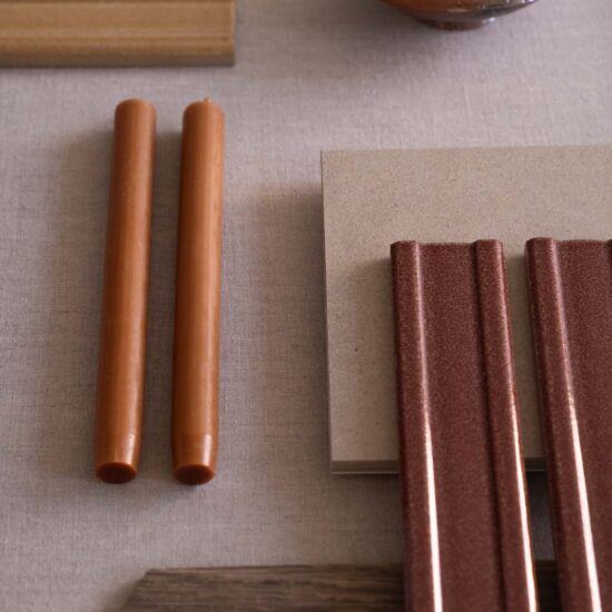 Various samples of materials, including wooden elements, surfaces with a gravel effect in warm tones, and smooth textures.