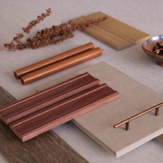 Sample of materials with warm tones and varied textures on a neutral surface, including decorative elements and utensils.