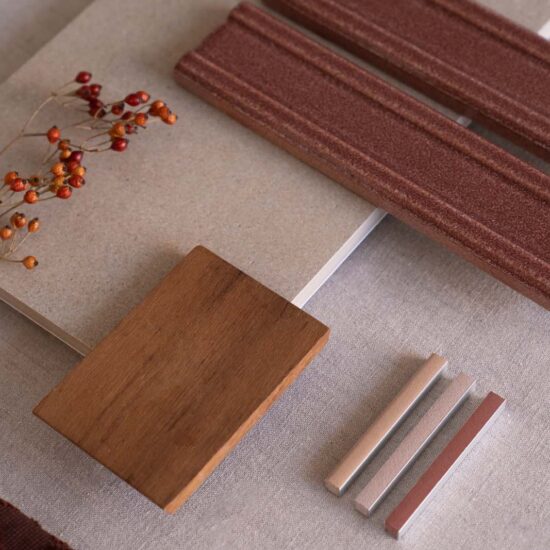 Samples of materials and fabrics on a table, with surfaces in shades of beige and brown, wooden details, and warm hues.