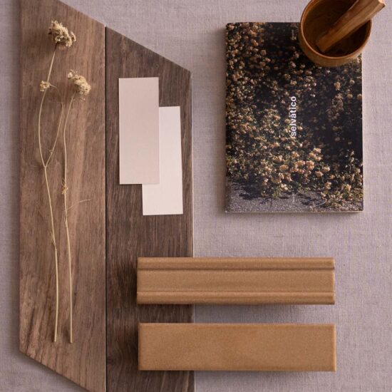 Composition of material samples with wood textures and warm tones, accompanied by a notebook and dry twigs.