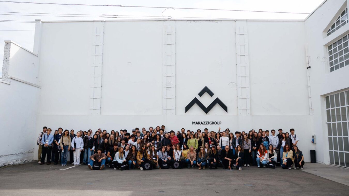 A group of about 150 people posing in front of the white wall with the "Marazzi Group" logo prominently displayed.