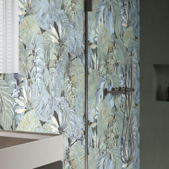 Bagno moderno con pareti decorate da foglie verdi e blu, lavabo minimalista e prodotti sulla mensola.